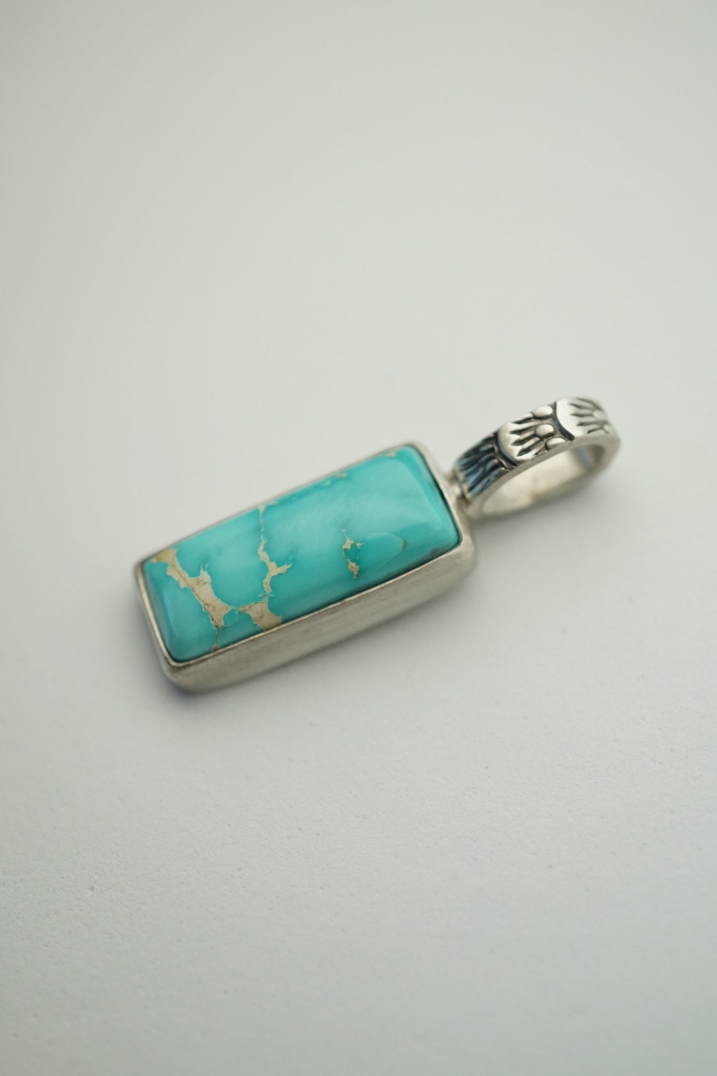 turquoise bar pendant in sterling silver on a white background